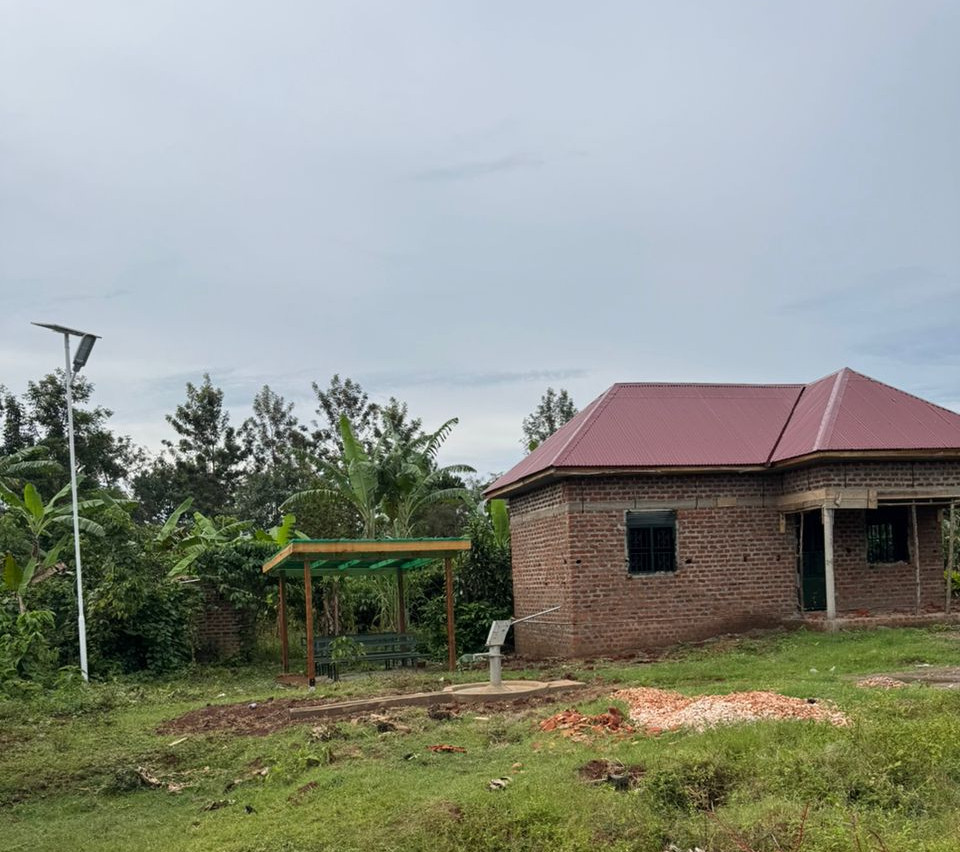 Links die Solarlaterne. Daneben die B&auml;nke und das Geb&auml;ude. Im Vordergrund sieht man die Pumpe.